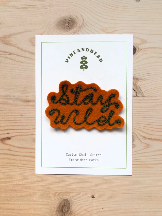 Custom chain stitch patch in tan and green on a white presentation card