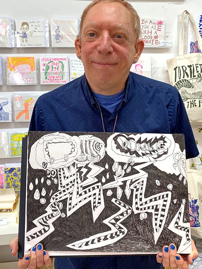 Happy artist holding original sketched artwork for rumble 100% organic cotton charity tea towel