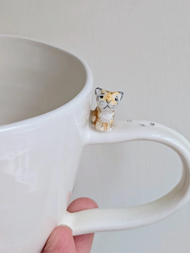 Handmade hello tiger cup in white earthenware ceramic with a tiny stripy cat and hand painted words