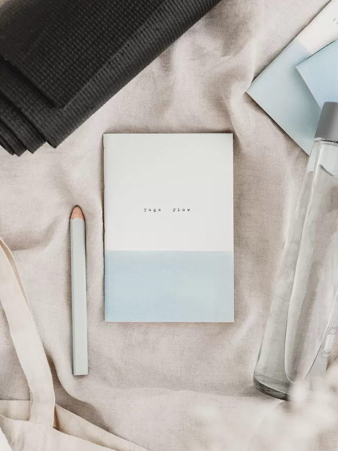 soft blue and white yoga journal with 'yoga flow' typed on the cover