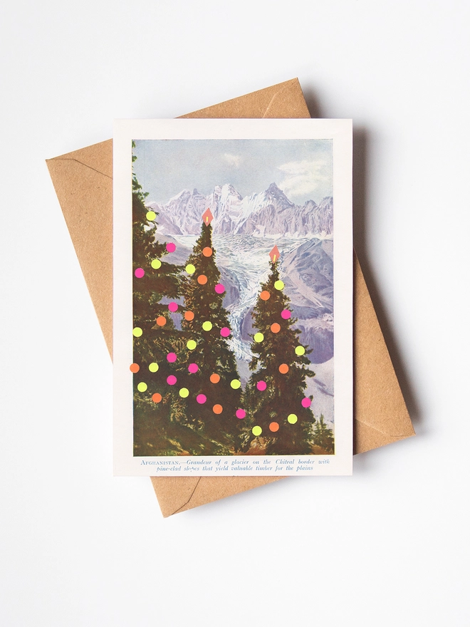 A vintage Christmas card with modern neon decorations and mountains in the distance.