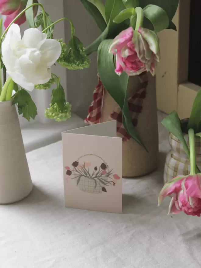 basket of tulips on a greetings card surrounded by tulips