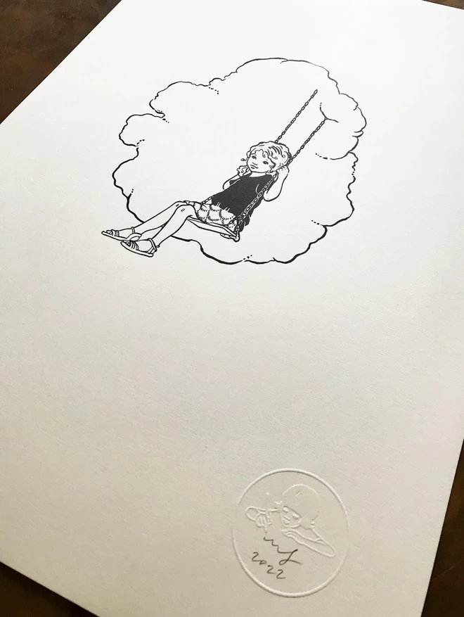 a close up of a limited edition letter press print featuring a vintage illustration of a girl sat on a swing in the clouds and an emboss stamp and artists signature