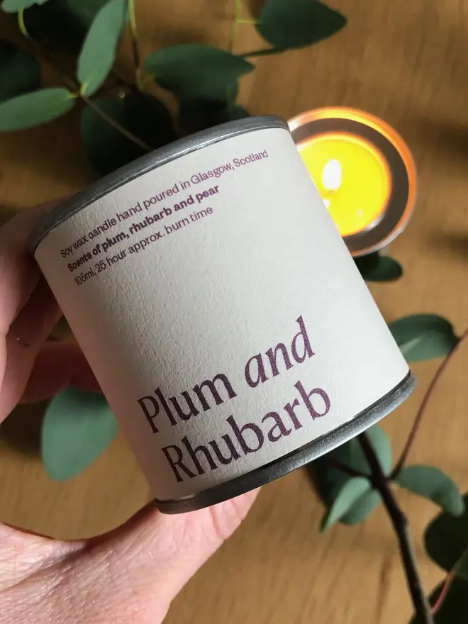 Plum & Rhubarb Candle  displayed against a wooden background. 