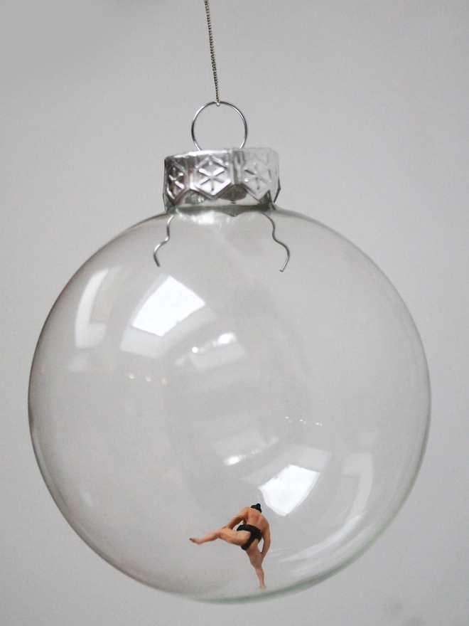 Miniature figure of a sumo wrestler in a glass Christmas bauble 