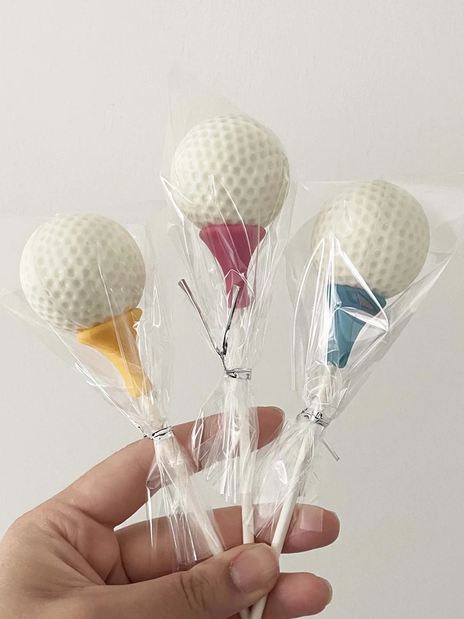 Golf Ball Cake Pops (Pack of 6, 12, 18, 24) held in hand showing size and detail.