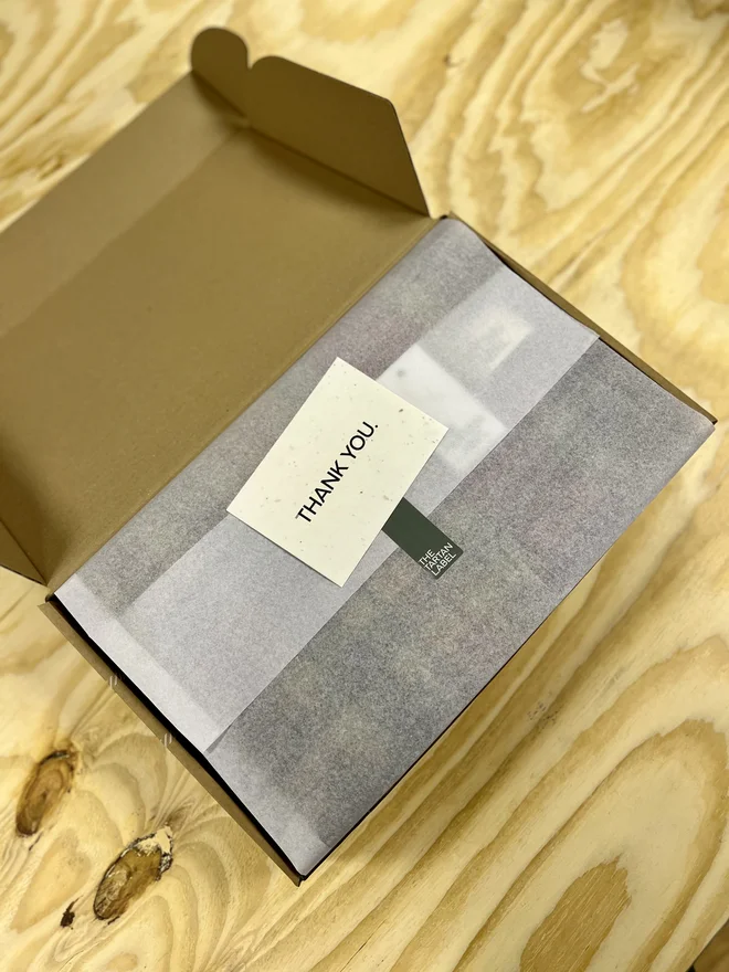 bannockbane silver tartan blanket. a gift wrapped blanket in a cardboard box.