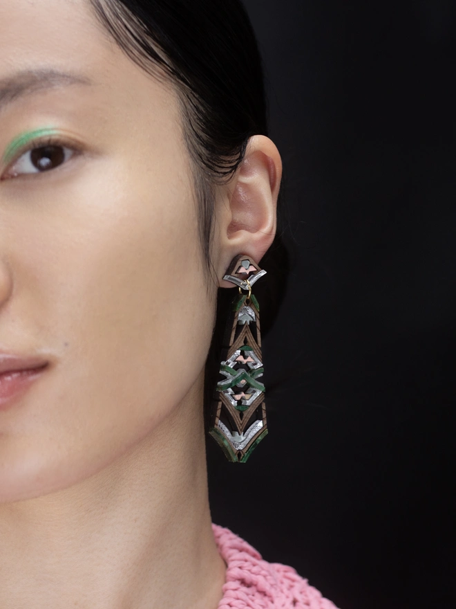 laser cut earring on close up model in front of black background