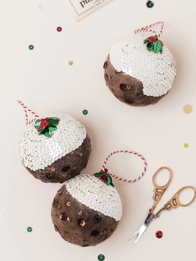 3 christmas puddings on a pale pink background