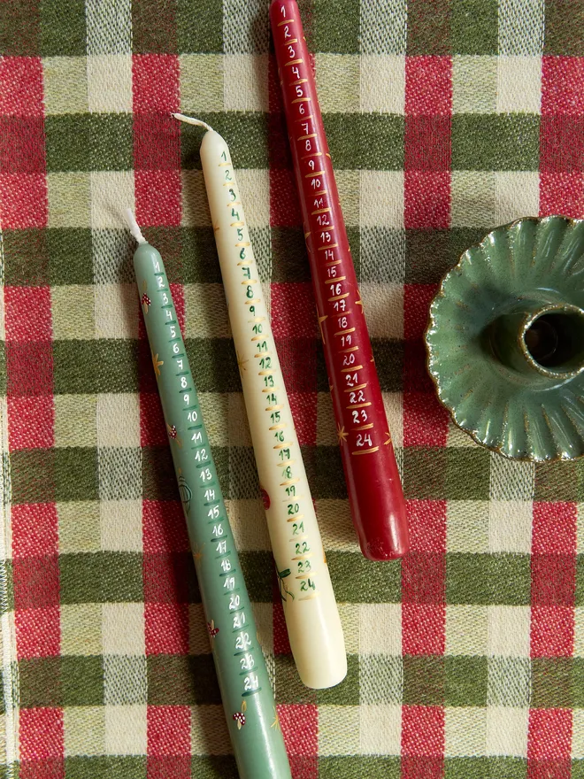 '24 Nights To Christmas' Advent Candle placeed on a checkered red and green tablecloth