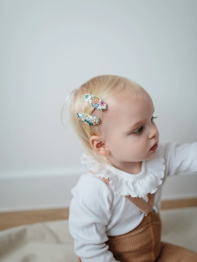 Close up of two hair clips on toddler with blonde hair 