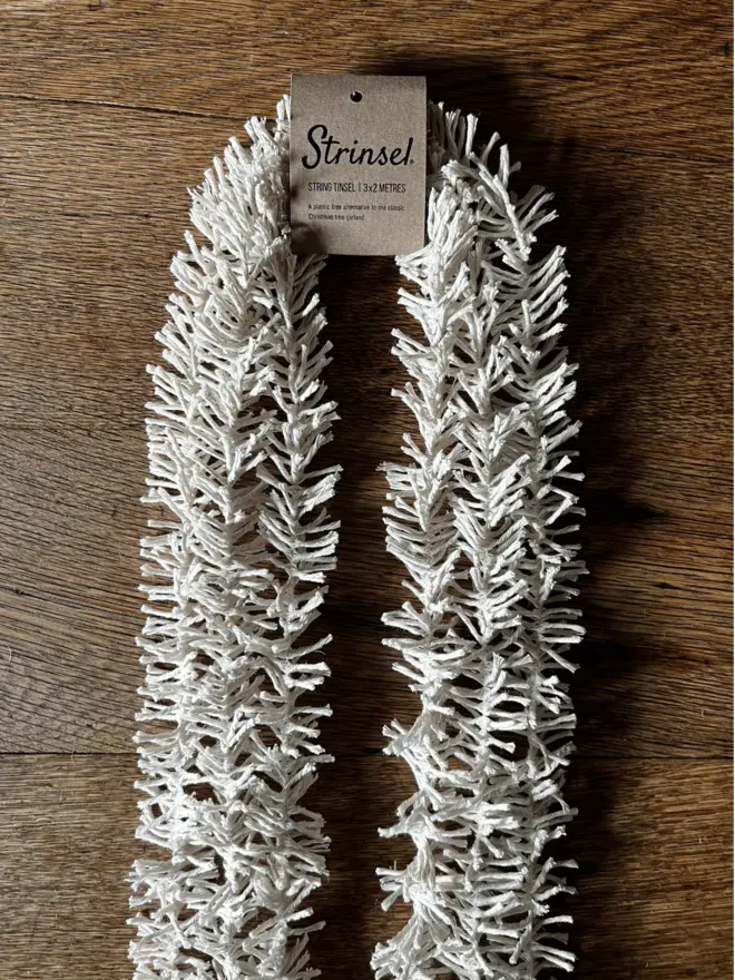 Multipack of Original Strinsel with label AKA Jute string tinsel on an oak table