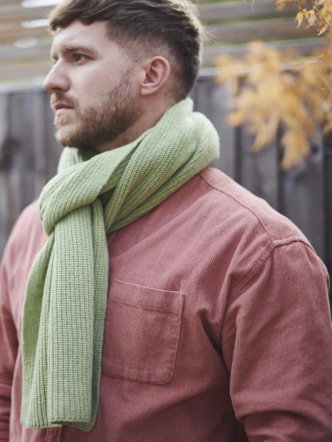 Lambswool Ribbed Scarf, a man wearing a colourful ribbed scarf outdoors. 