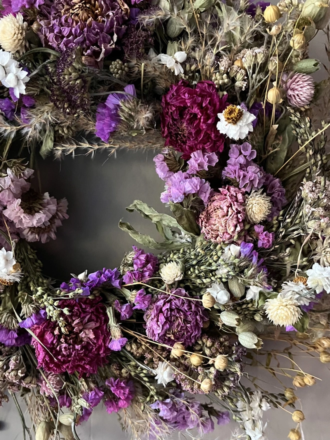 Pink and purple flower wreath made with a selection of seasonal blooms and dried dahlias. 