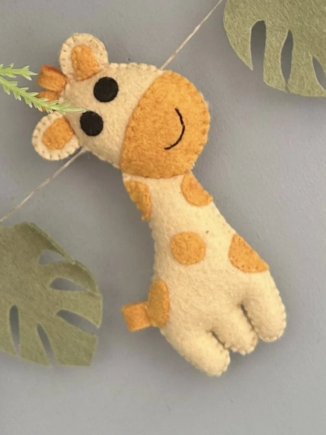 Nursery Safari Garland, a safari themed garland hanging in a child's bedroom against a grey backdrop. 