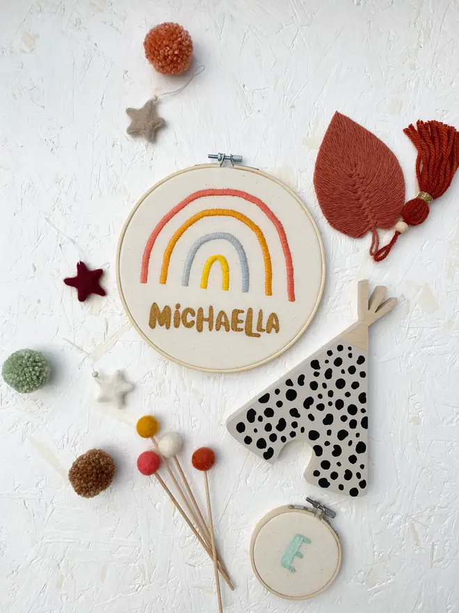 personalised name and rainbow embroidered hoop. cotton hoop embroidered with a name and colourful rainbow.