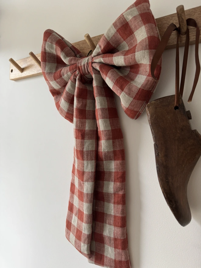 Checked red and brown bow on a rail with a wooden shoe 