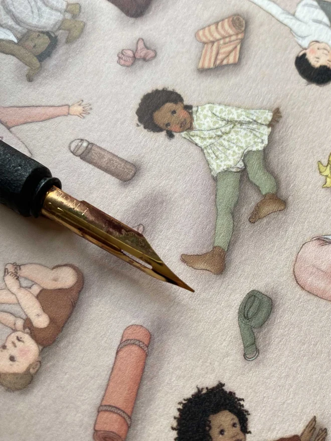 close up of a pen nib to show the miniature detail of a greeting card featuring children doing yoga poses