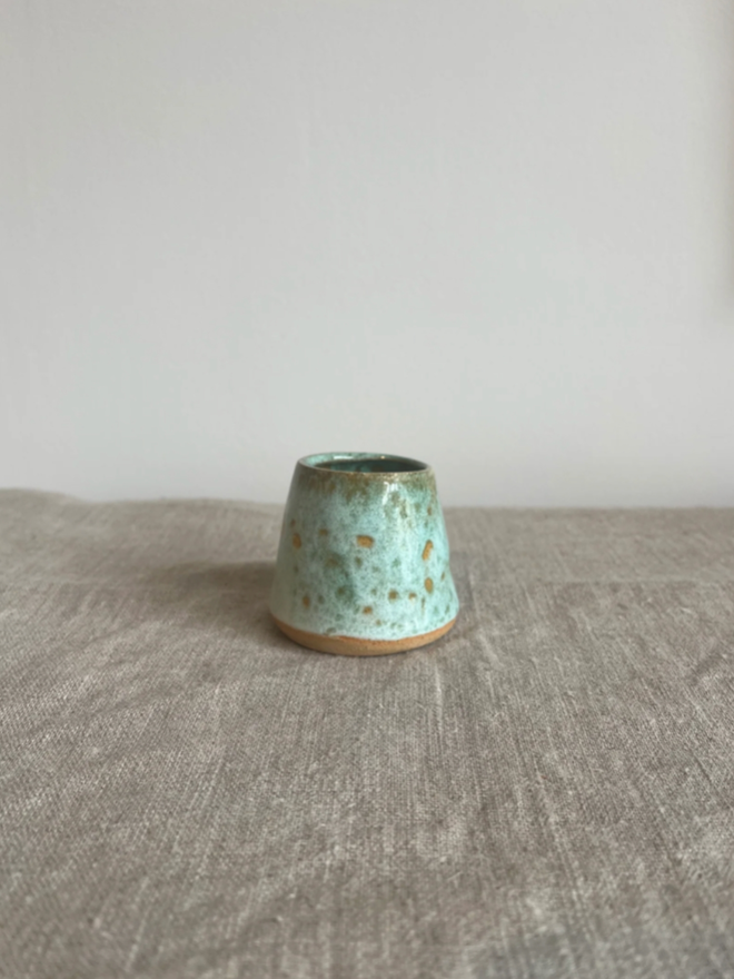 Egg Cup. A green egg cup with subtle light and dark patches.