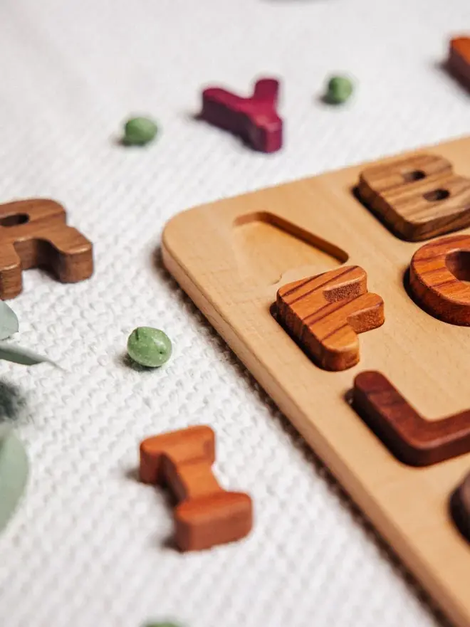 Wooden Uppercase Alphabet Puzzle Heirloom Toy, on a table. 