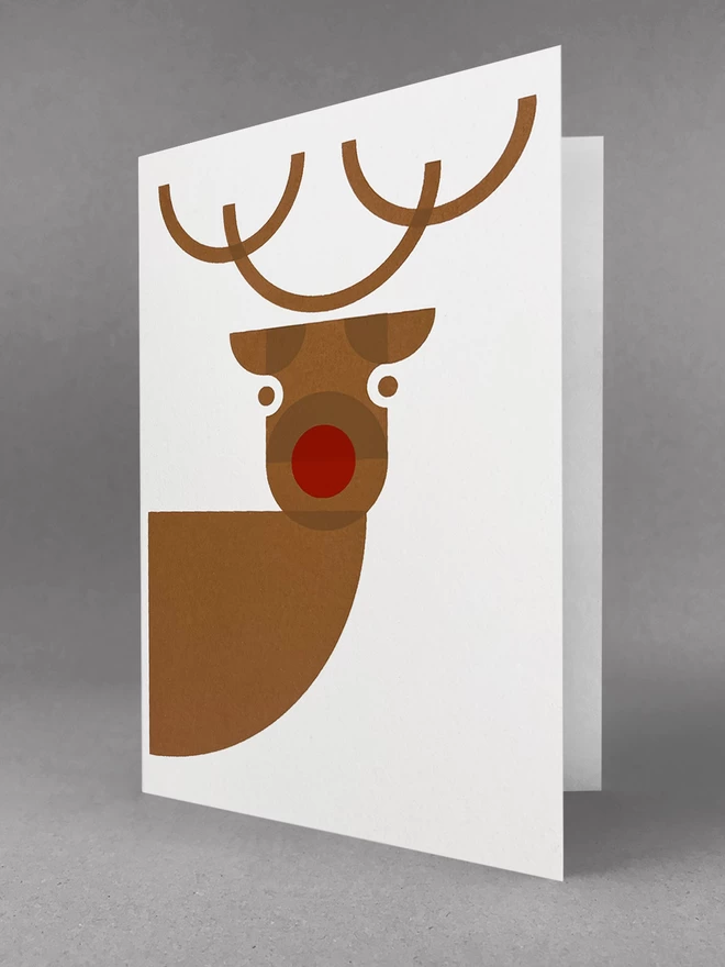 Cheeky reindeer looking right at you, peers from this handprinted christmas card, stood slightly open in a studio set. Screenprinted in browns and red.