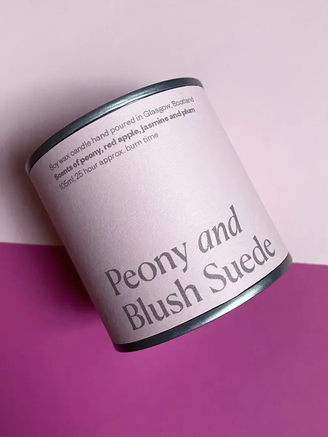 Peony and Blush Suede Soy Wax Candle Tin, against a pink background. 