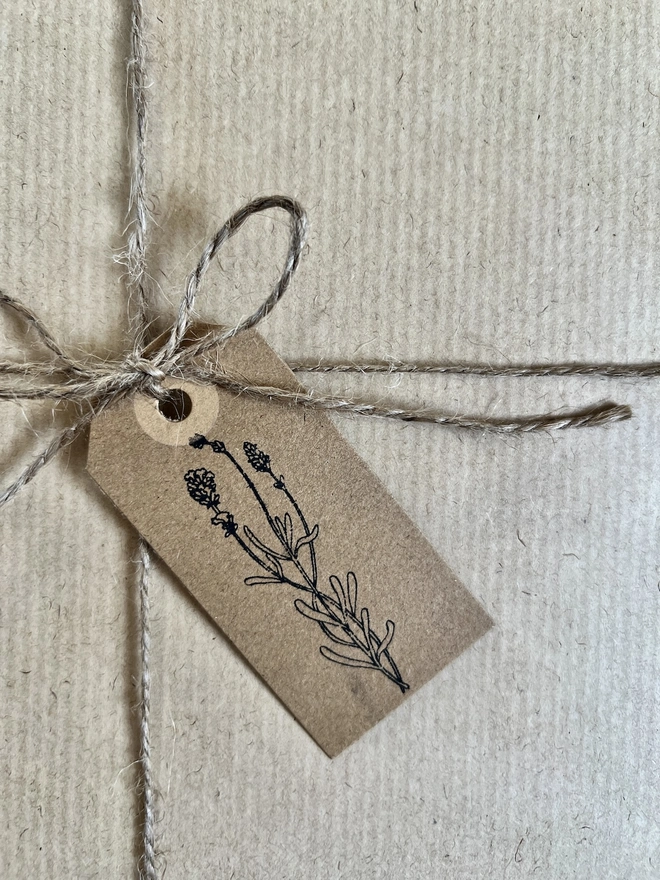 close up of brown gift tag hand stamped with flower design