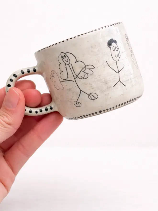 A ceramic espresso mug with stick men figures draw by a child
