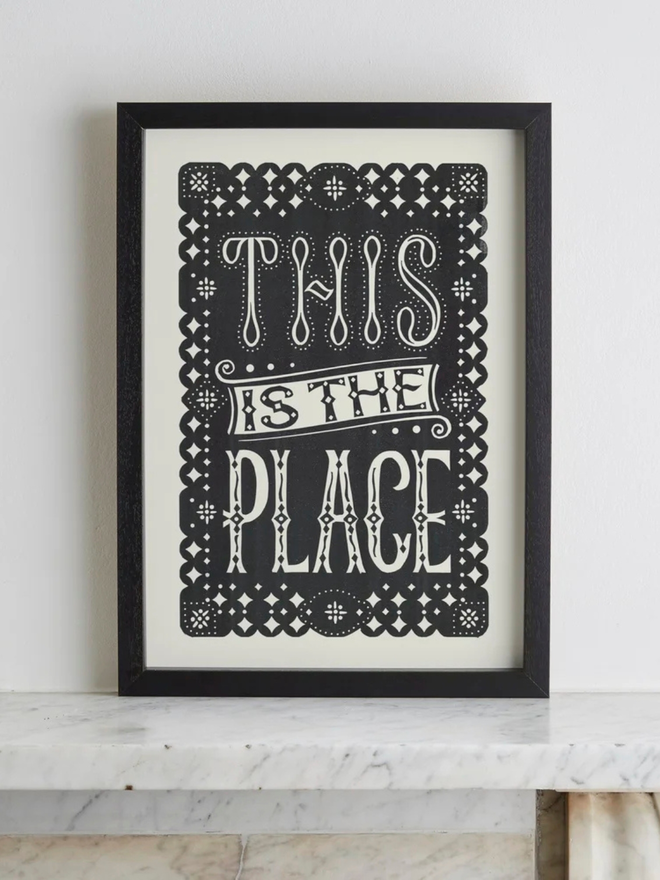 this is the place linocut. a linocut phrase printed with black paint.