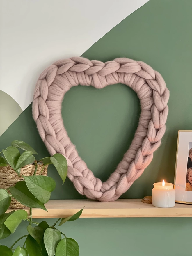 Mink pink woolly heart wreath on a shelf