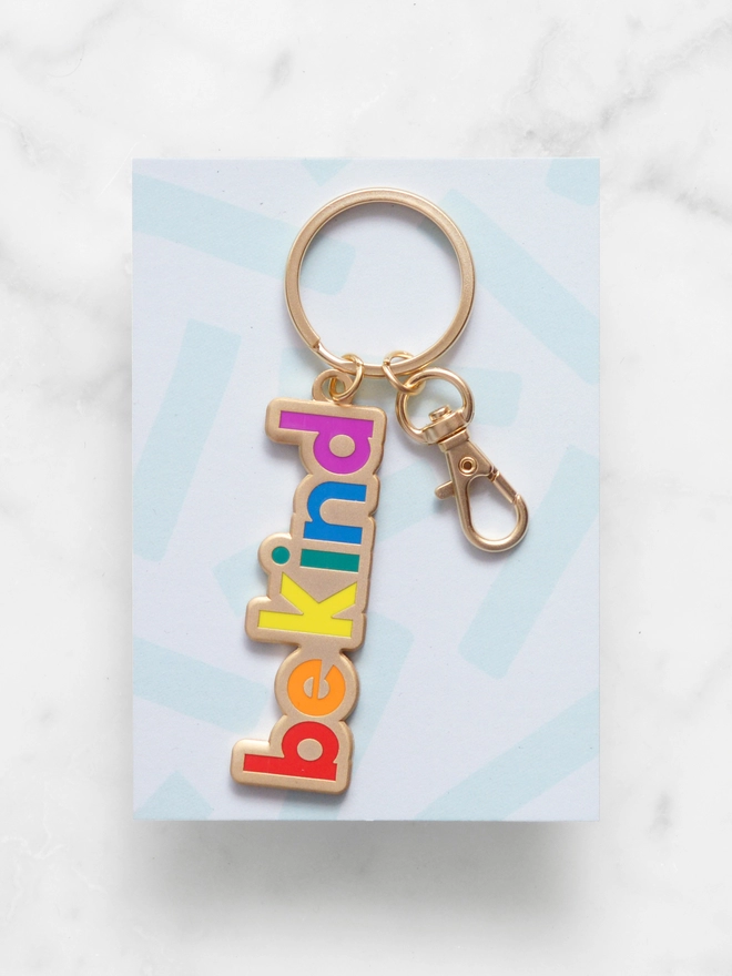 Enamel keyring with 'Be Kind' design in rainbow colours