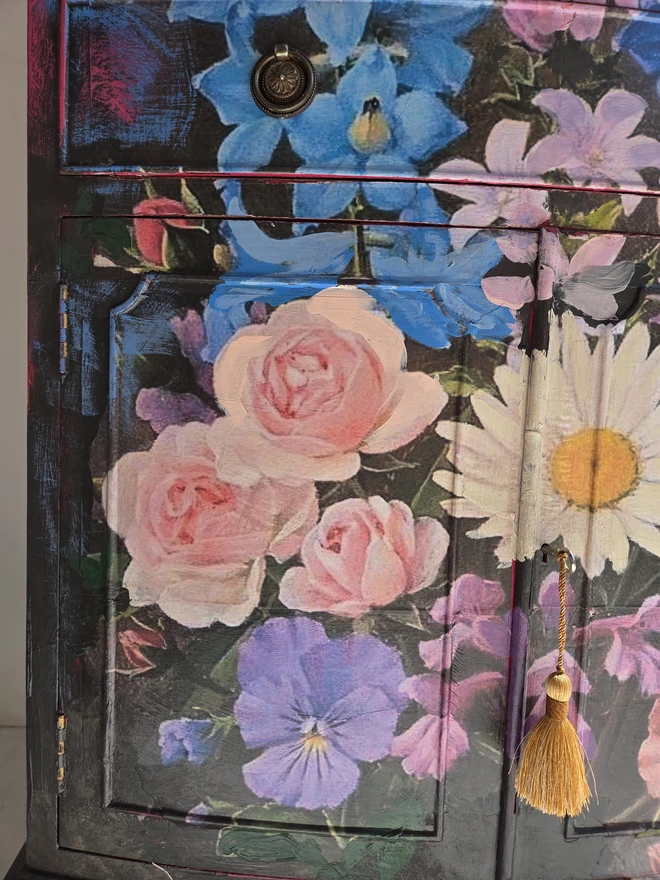 Close up of painted vintage wooden cabinet with pink, blue and floral decoration
