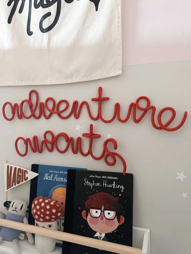 "adventure awaits" motivational phrase hanging up on a kids bedroom wall