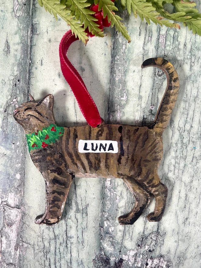 Tabby Cat Christmas Decoration with velvet ribbon placed onto a book about cats 