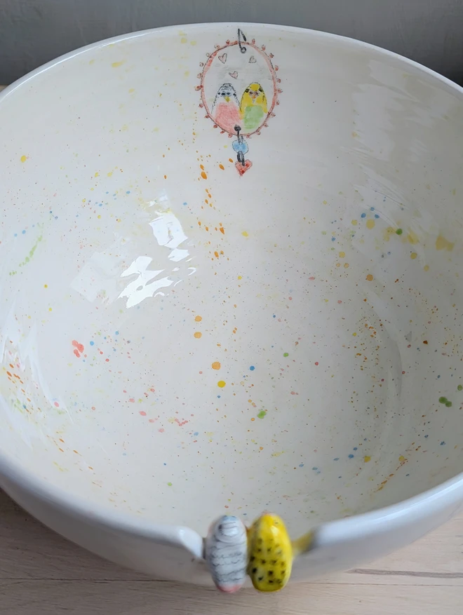 ceramic budgie couple bowl with splattered colourful design and hand painted mirror inside showing the two birds admiring themselves