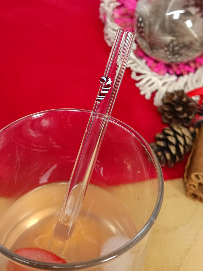 close up of a short candy cane straw in a glass