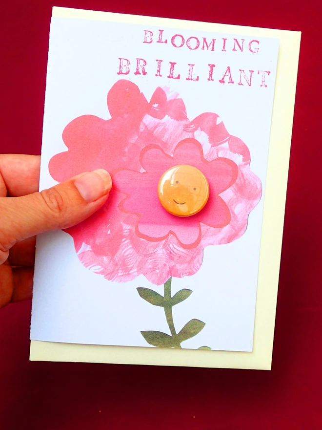 brilliant pink flower greeting card with happy face pin badge