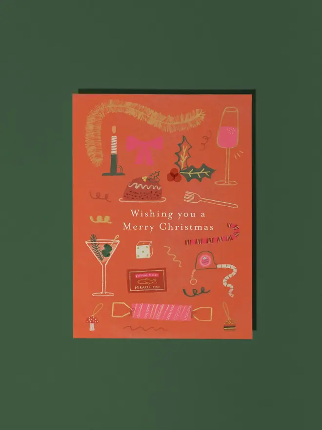 merry christmas illustrated christmas food card. brick red card illustrated with various christmas items including a christmas pudding, wine, candle and cracker.