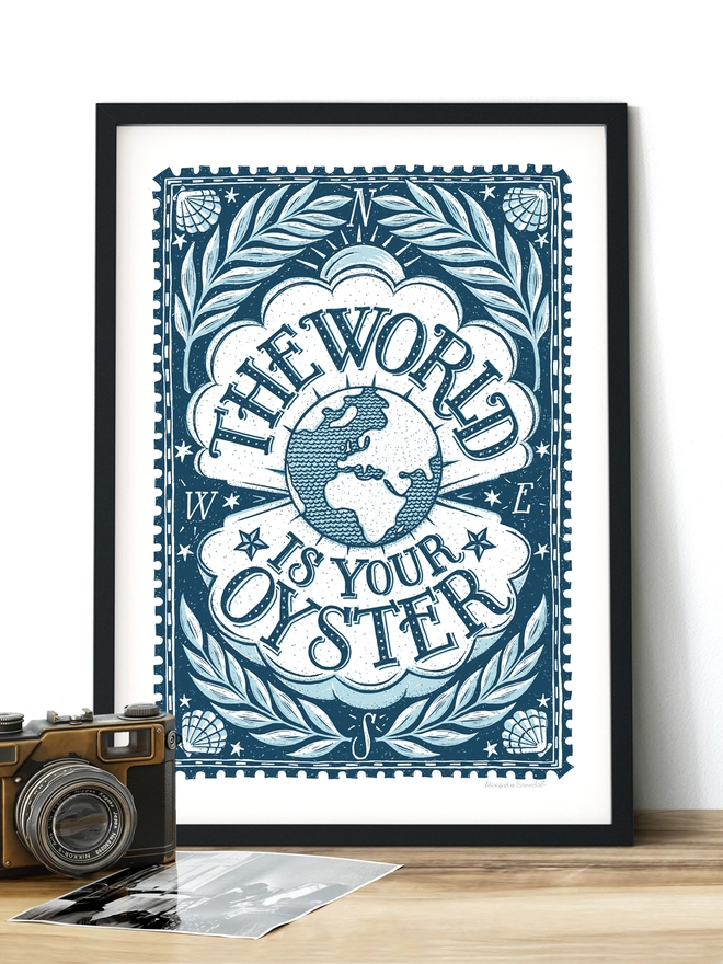 the world is your oyster blue and white nautical travel print in black frame with vintage camera