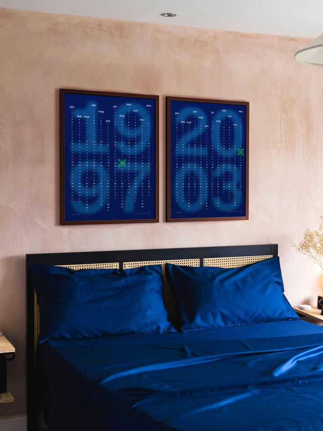 Pair of matching framed Blue Minx Personalised Date Posters on clay wall, above blue bedding