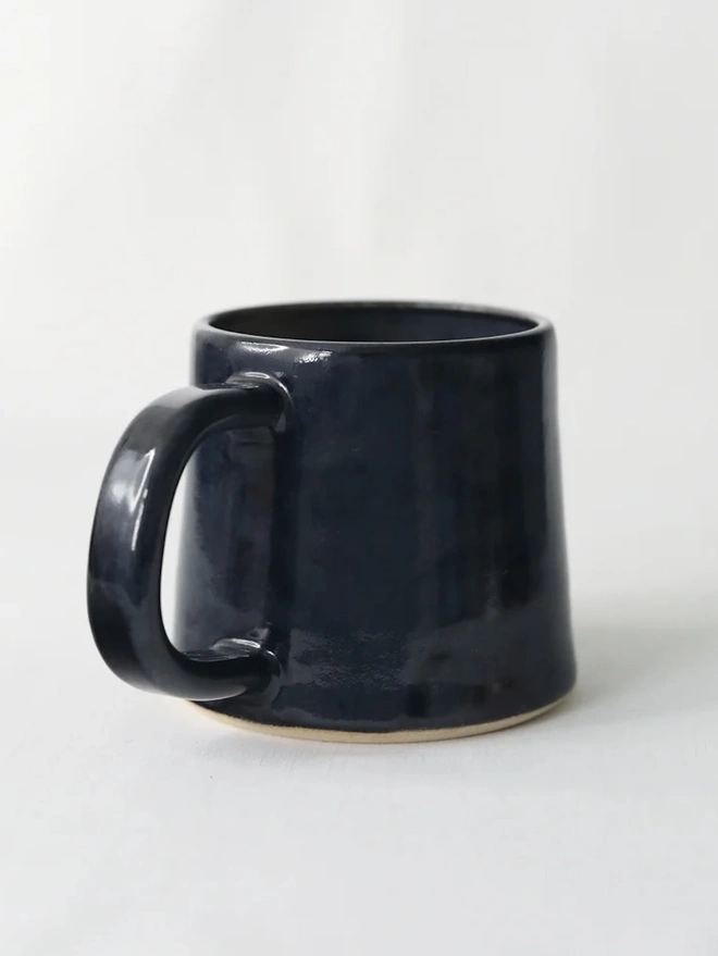 Ceramic Standard Mug, a colourful ceramic mug sitting on a plain surface against a grey backdrop. 