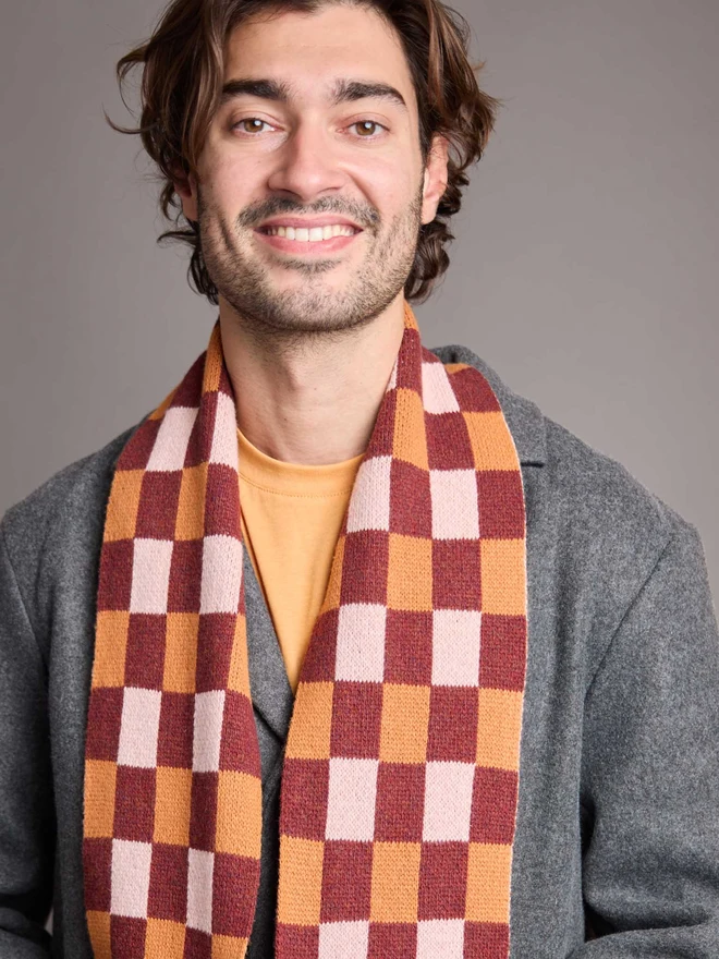 Red And Rust Patterned Wool Scarf Modelled By A Man In A Grey Coat