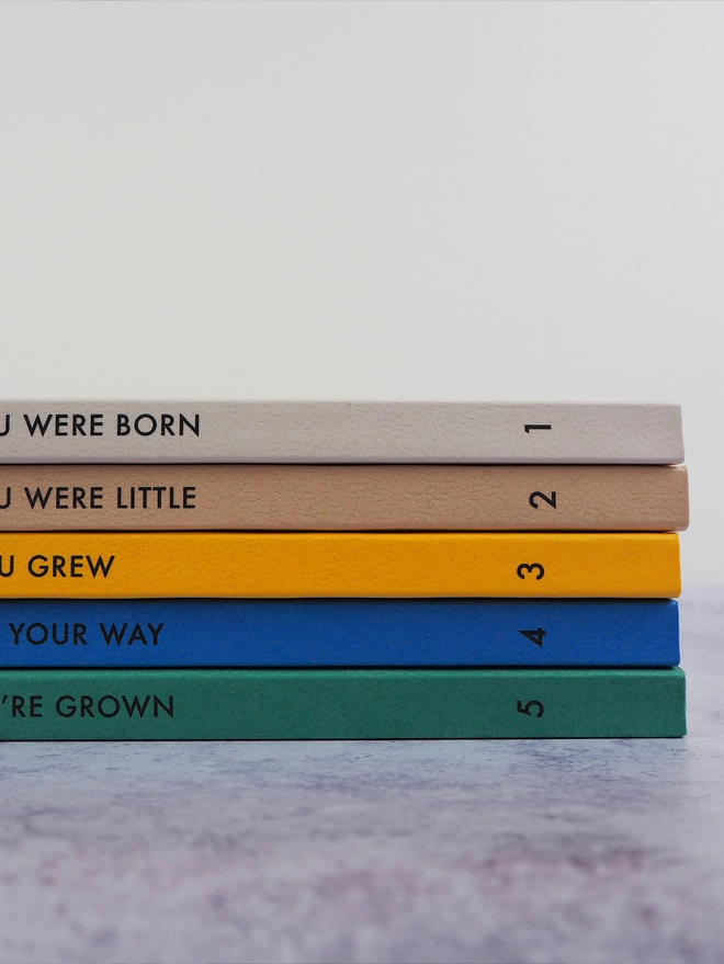 a stack of notebooks with personalised text down the spine and the numbers 1-5