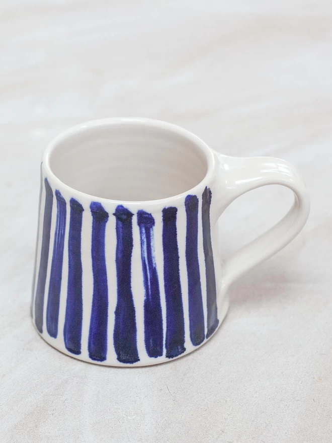 Gloss handmade mug with cobalt blue hand-painted stripes seen from above