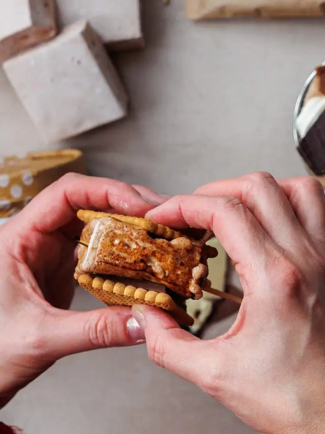 The-Mallow-Makers-close-up-of-hands-holding-smores-toasted-marshmallow