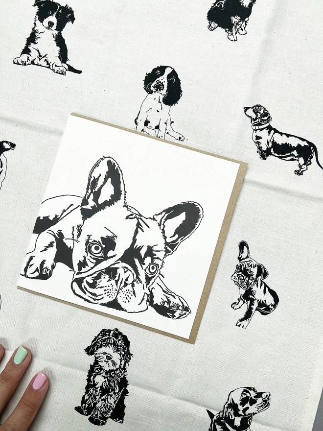 Big dog Frenchie in the middle of the puppies tea towel