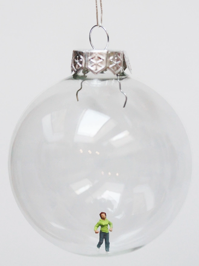 Miniature figure of a female runner in a glass Christmas bauble 