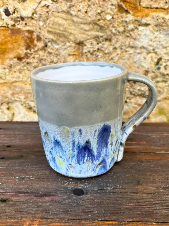 Shoreline Standard Mug, a colourful mug placed on a wooden surface. 