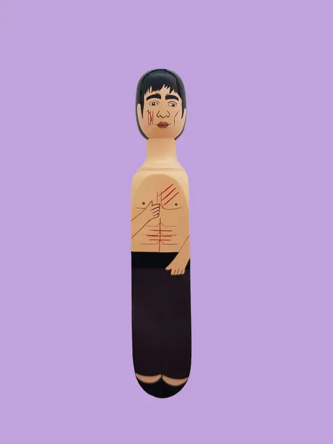 Wooden Door Stopper (Brucey), a colourful wooden door stop sitting on a white surface. 