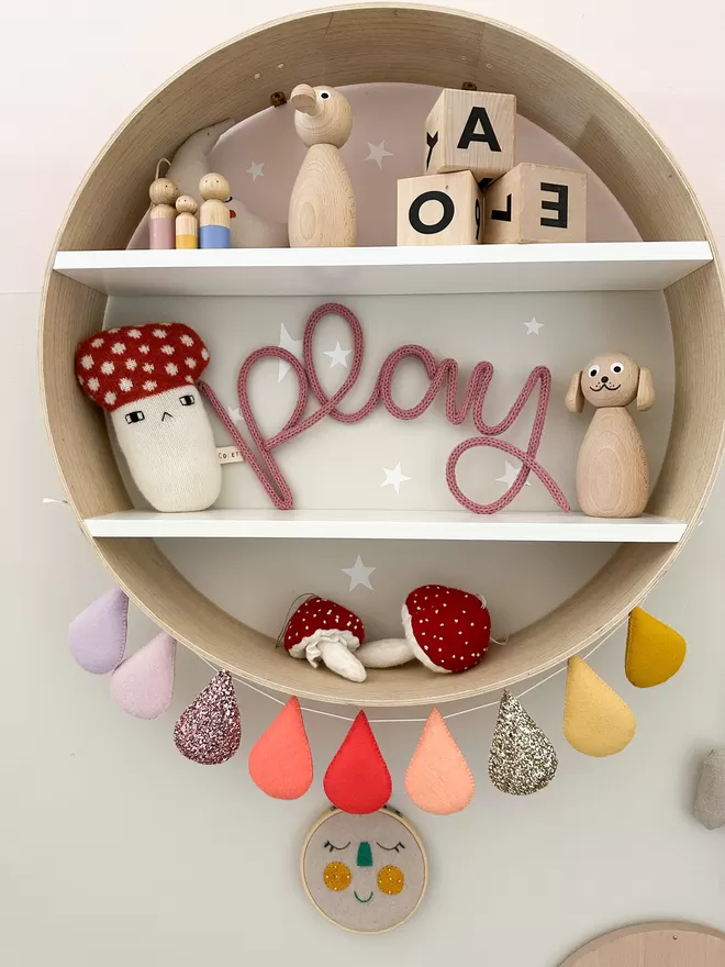 'play' knitted wire word sign on a shelf decorating a child's room. 